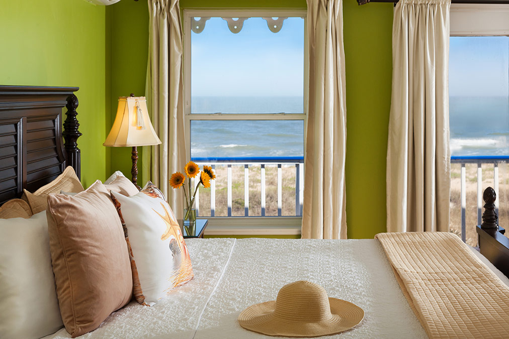 Beachcomber, looking over bed and out through two windows at the ocean